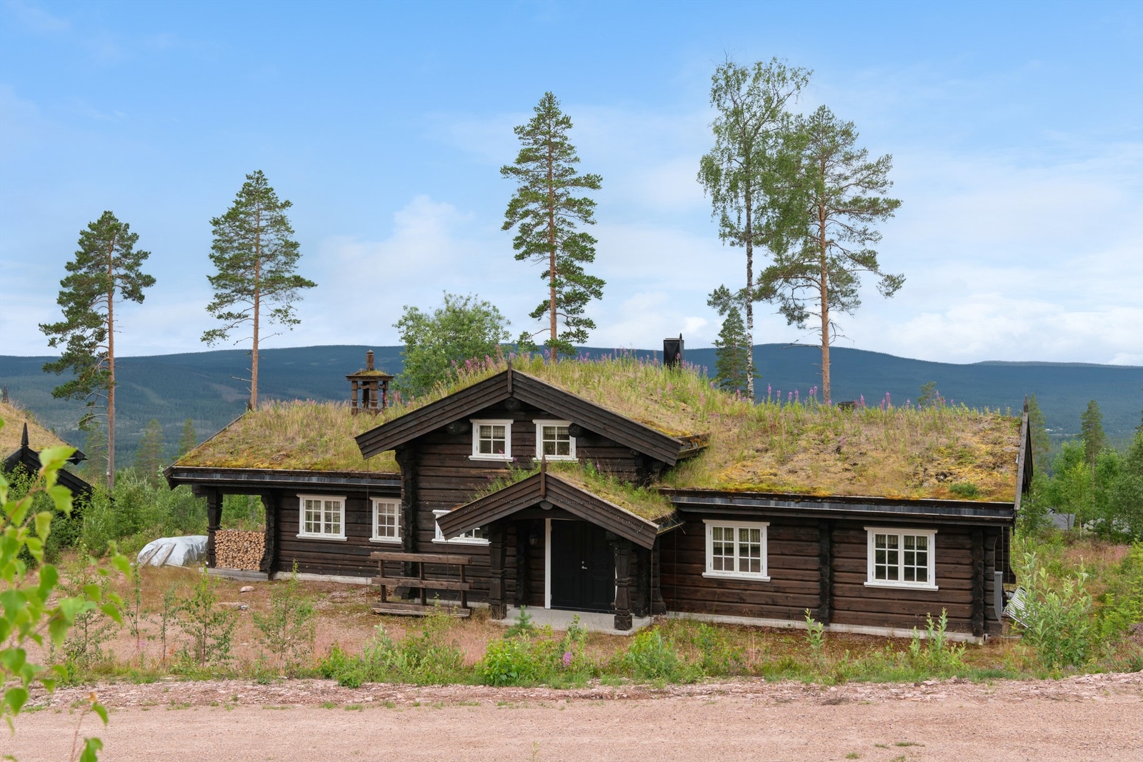 Klassisk fjellarkitektur med dobbelfløyet inngangsdør og robuste materialvalg gir et eksklusivt førsteinntrykk. Galleribilde