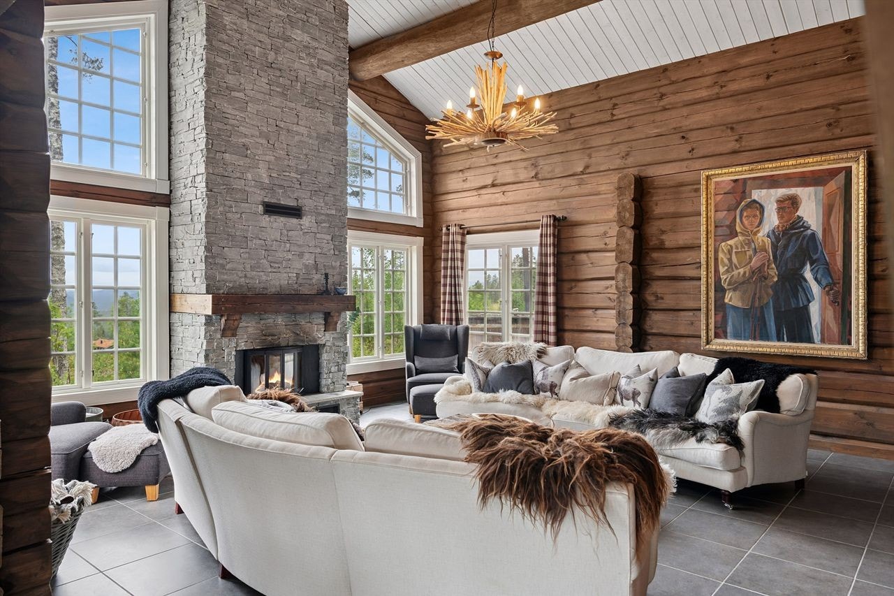 Stuen har imponerende takhøyde, store vinduer og peisinnsats fra Nordpeis med murt skiferomramming Galleribilde