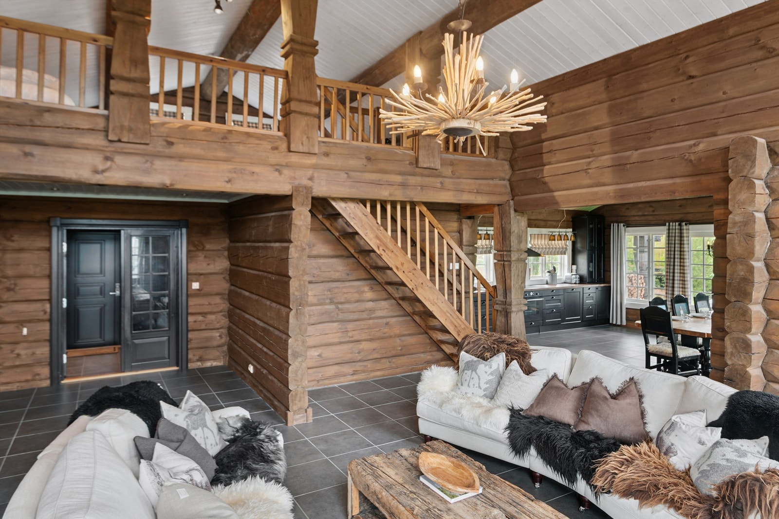 Åpen stue med synlige bjelker og hems gir en luftig atmosfære og god romfølelse Galleribilde