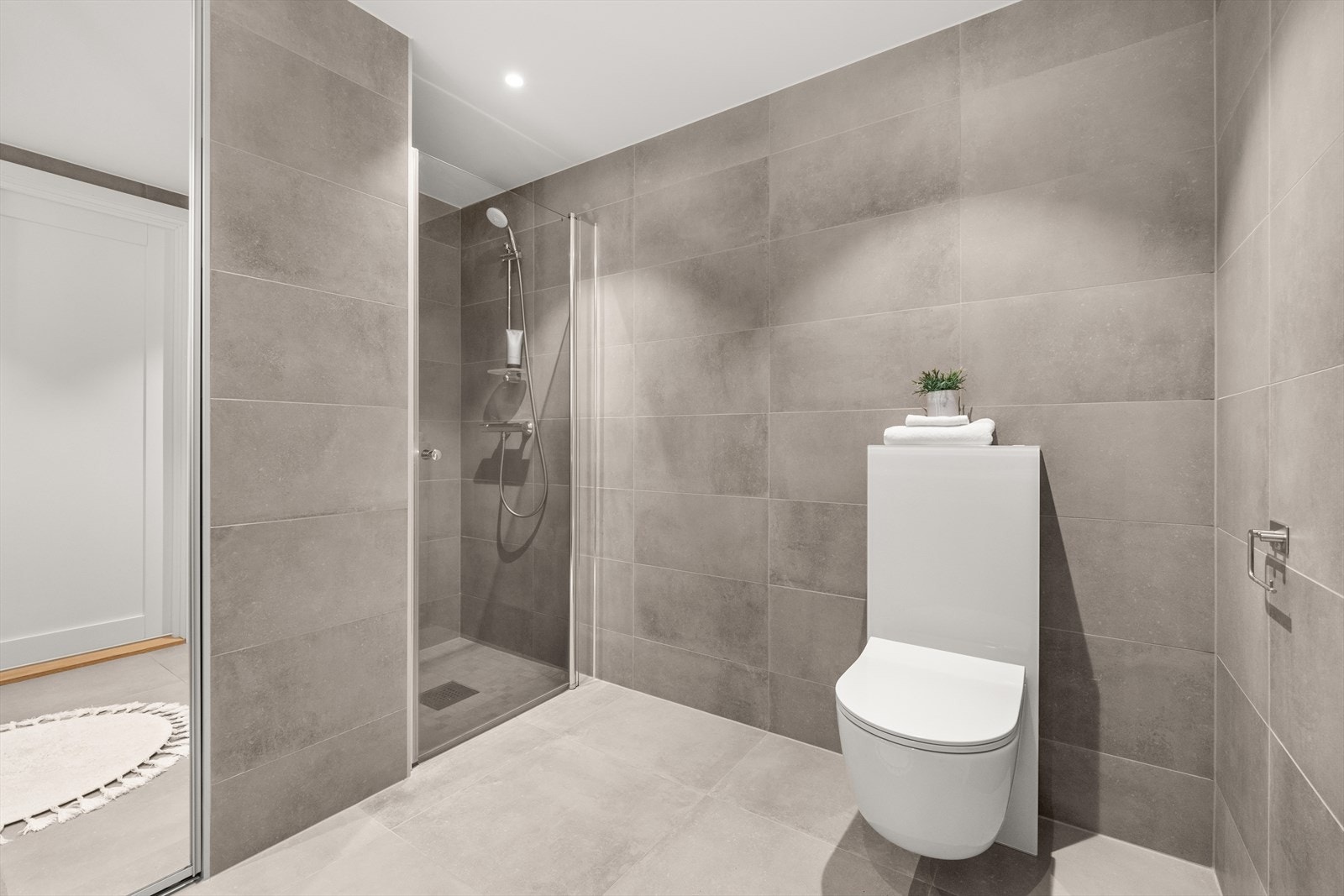 Badet har varmekabler i gulv og dimbare downlights i himling Galleribilde