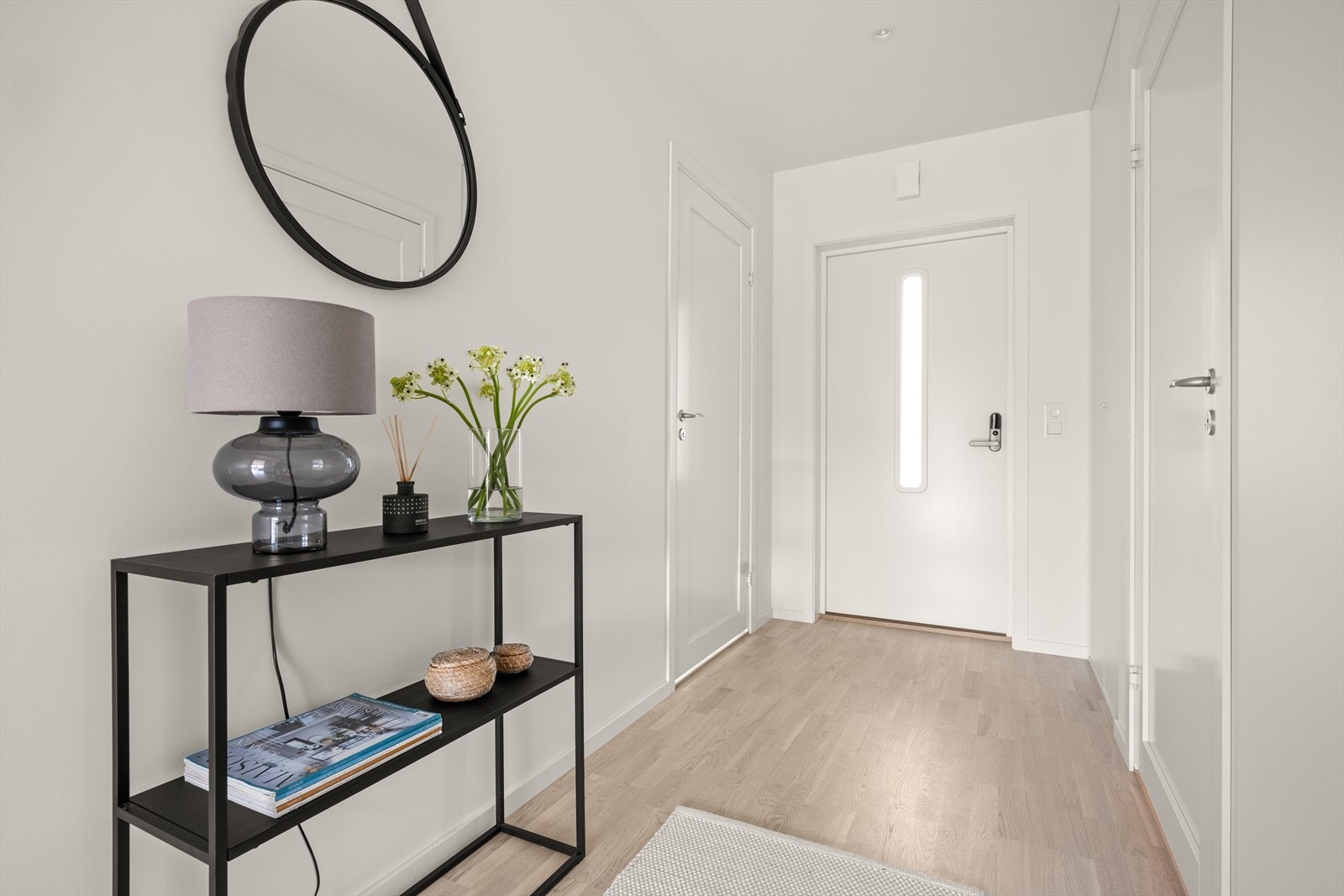 Lys og innbydende gang med dimbare downlights i himling og et meget praktisk plassbygget garderobesystem bygget inn i vegg Galleribilde