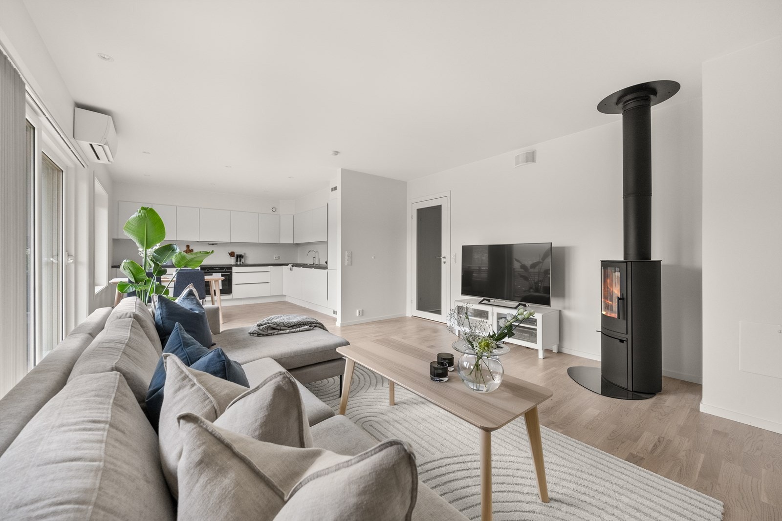 Stue og kjøkken ligger i åpen løsning med identisk fargetone på vegger og himling hvor den listfrie overgangen gir en ekstra "boost" på den romslige følelsen Galleribilde