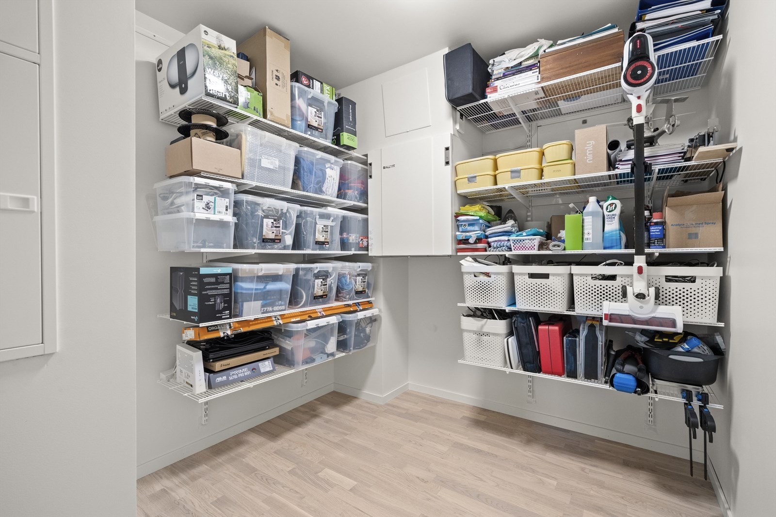 Romslig og praktisk bod med innredning bestående av hyllesystem på skinner Galleribilde