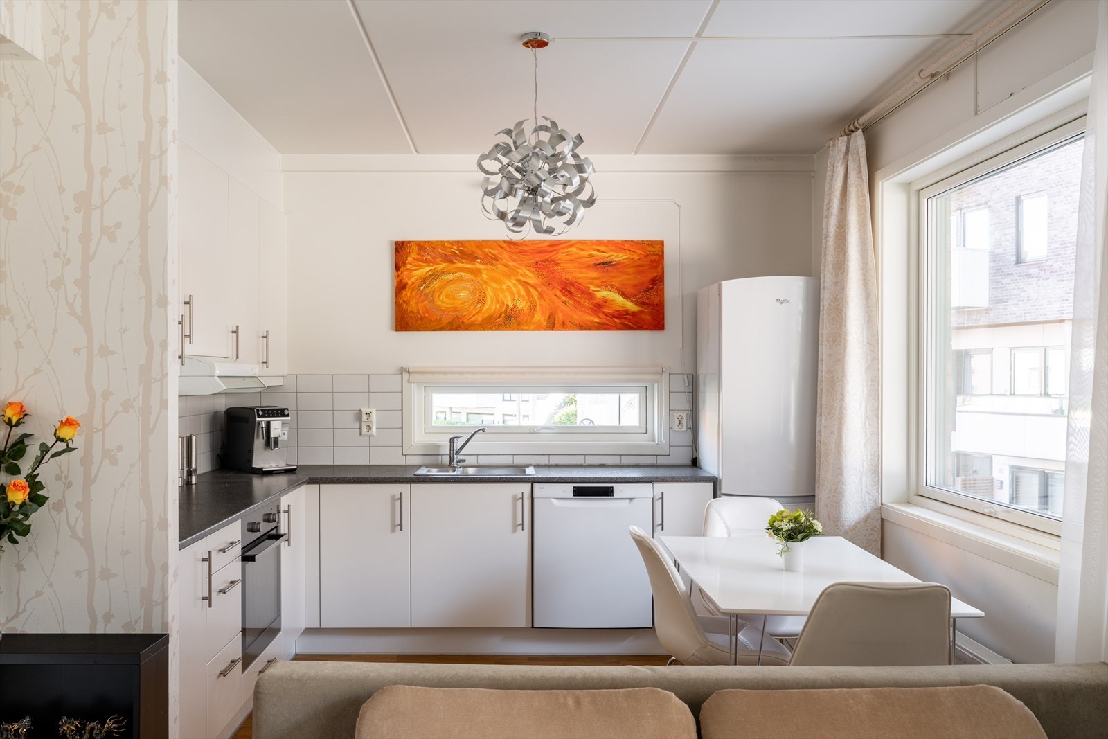 Kjøkkenet fremstår lyst og funksjonelt med glatte, lyse skapfronter som gir et stilrent uttrykk. Galleribilde