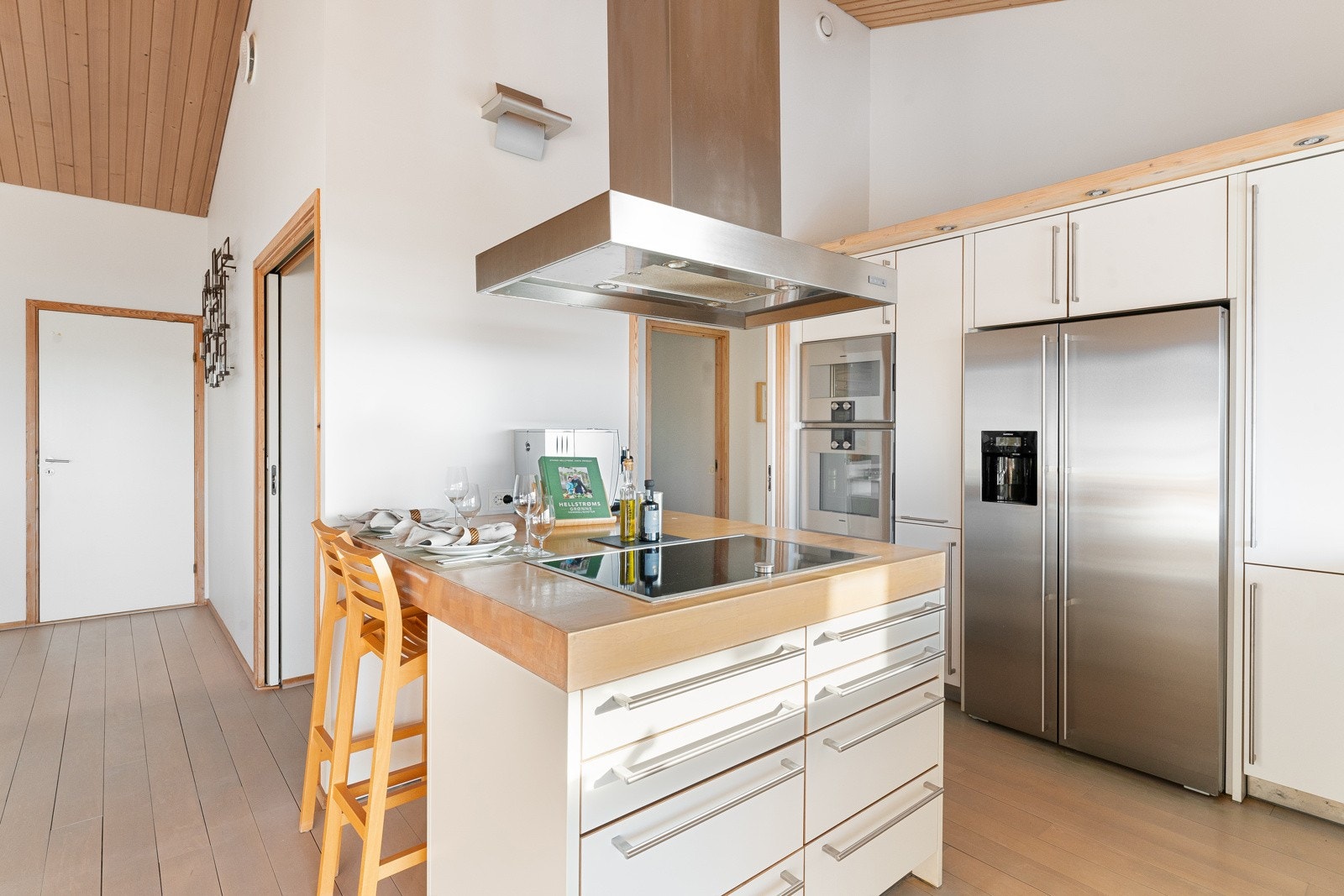 En praktisk barløsning med sitteplasser skaper et naturlig skille mellom spisestuedelen og kjøkkenet. Galleribilde