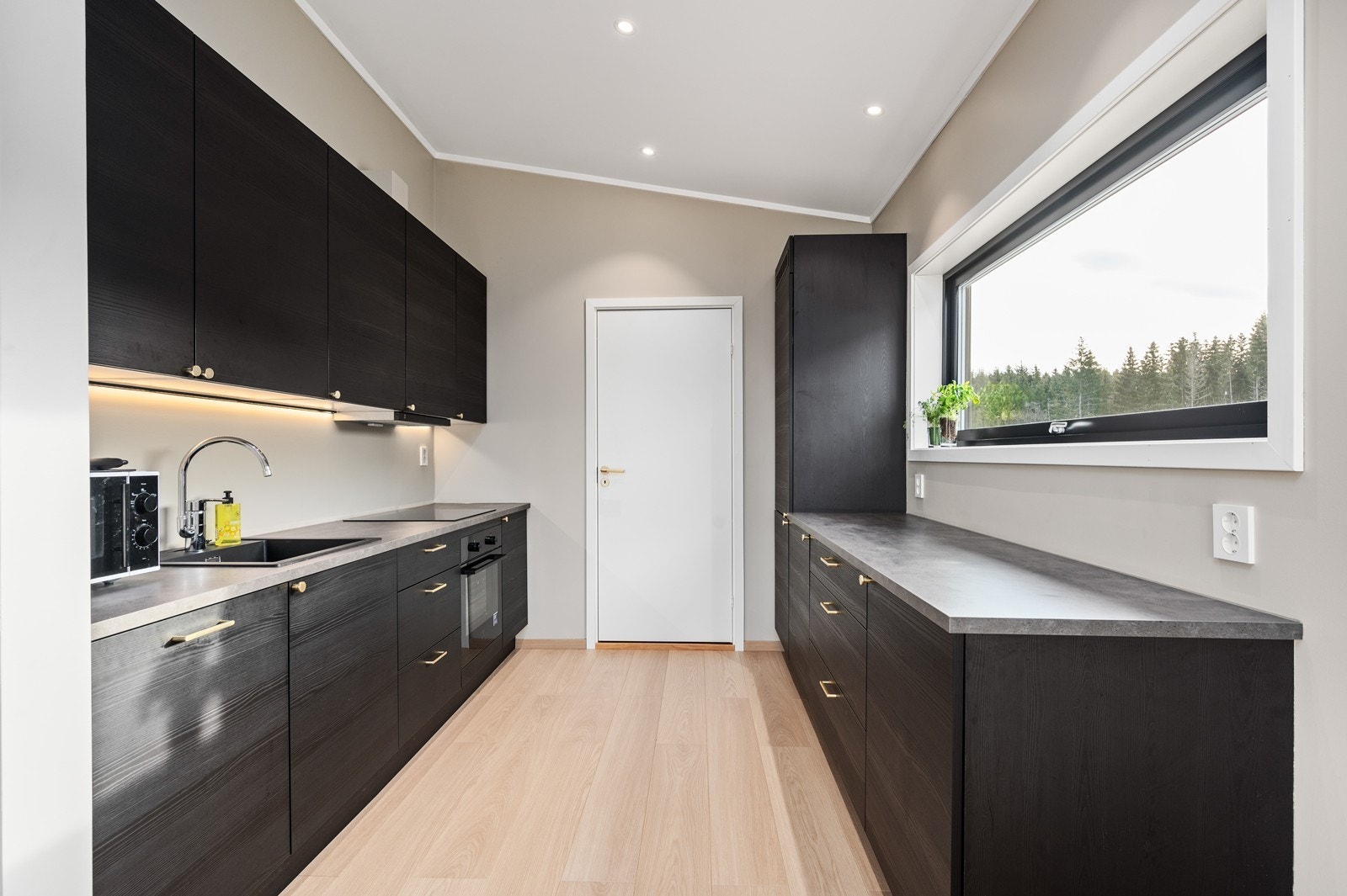 Kjøkkenet har en moderne innredning med glatte fronter og laminat benkeplate. Galleribilde