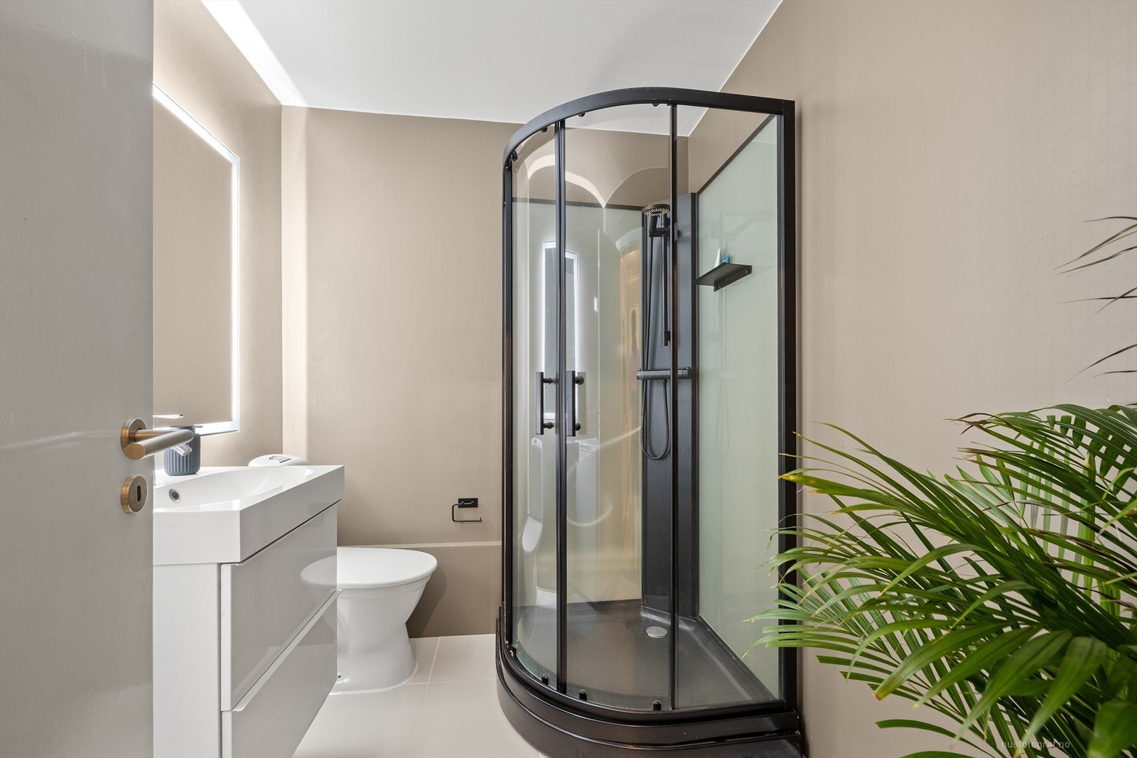 Badet har innredning bestående av dusjkabinett, klosett, servant m/servantskap og opplegg til vaskemaskin. Galleribilde