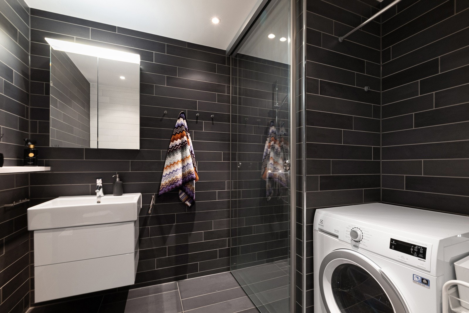 Badet har opplegg for vaskemaskin og plass til tørketrommel i nisje. Galleribilde