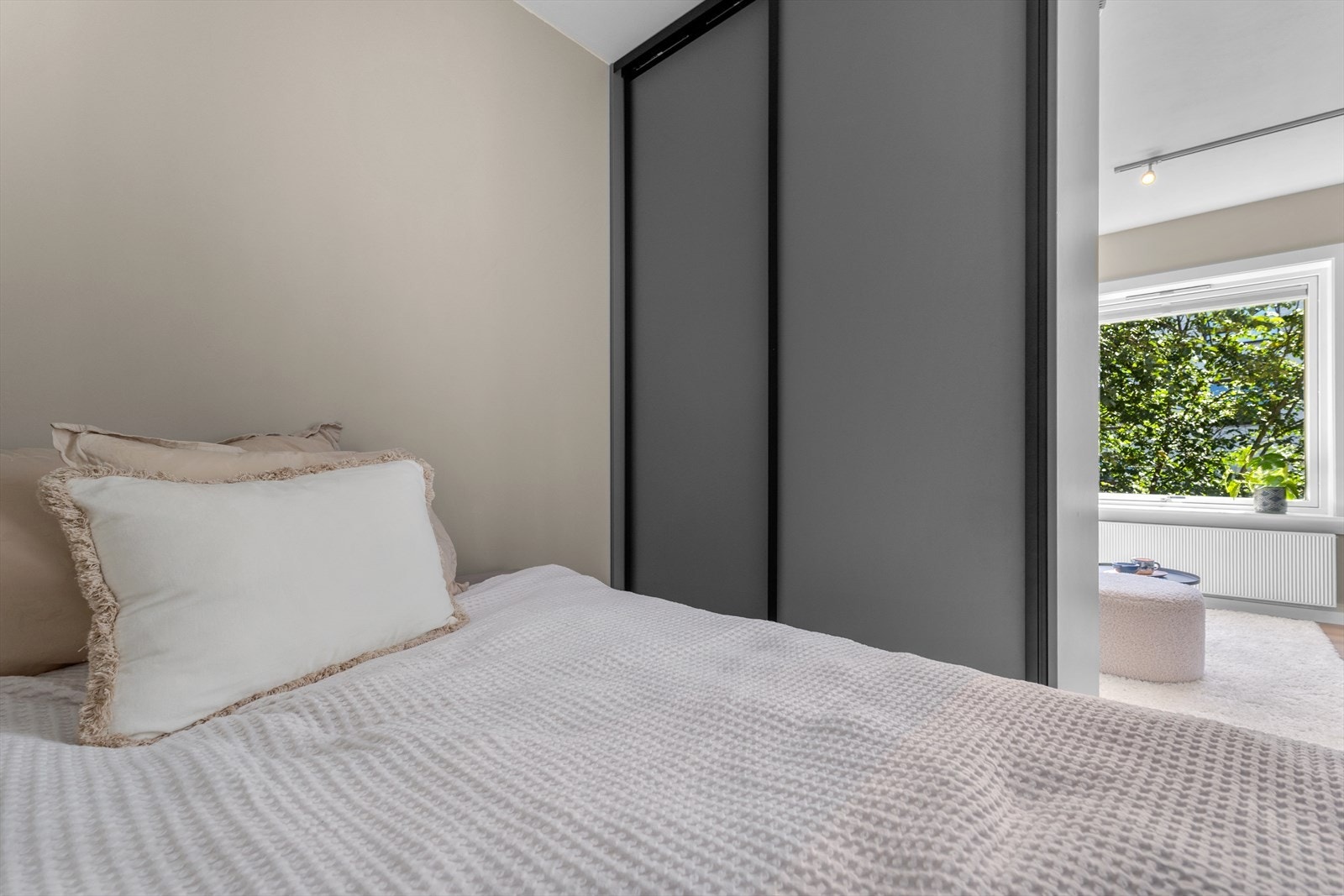 Plassbygd skyvedørsgarderobe som gir god plass til oppbevaring og fungerer som et meget pent romskille. Galleribilde