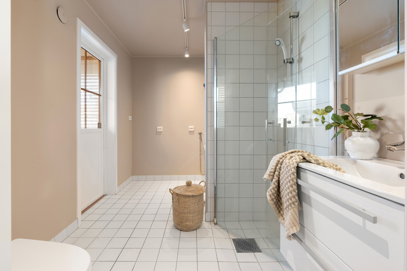 Badet i 1. etasje framstår romslig og er utformet slik at det kan være kombi bad og vaskerom. Her er det også egen inngang til vaskeromsdelen av badet.
