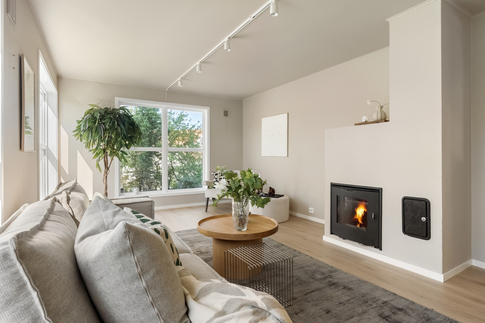 Stuen i 1. etasje har god plass for flere sittegrupper. Vedfyringen bidrar til en behagelig temperatur og en koselig atmosfære.