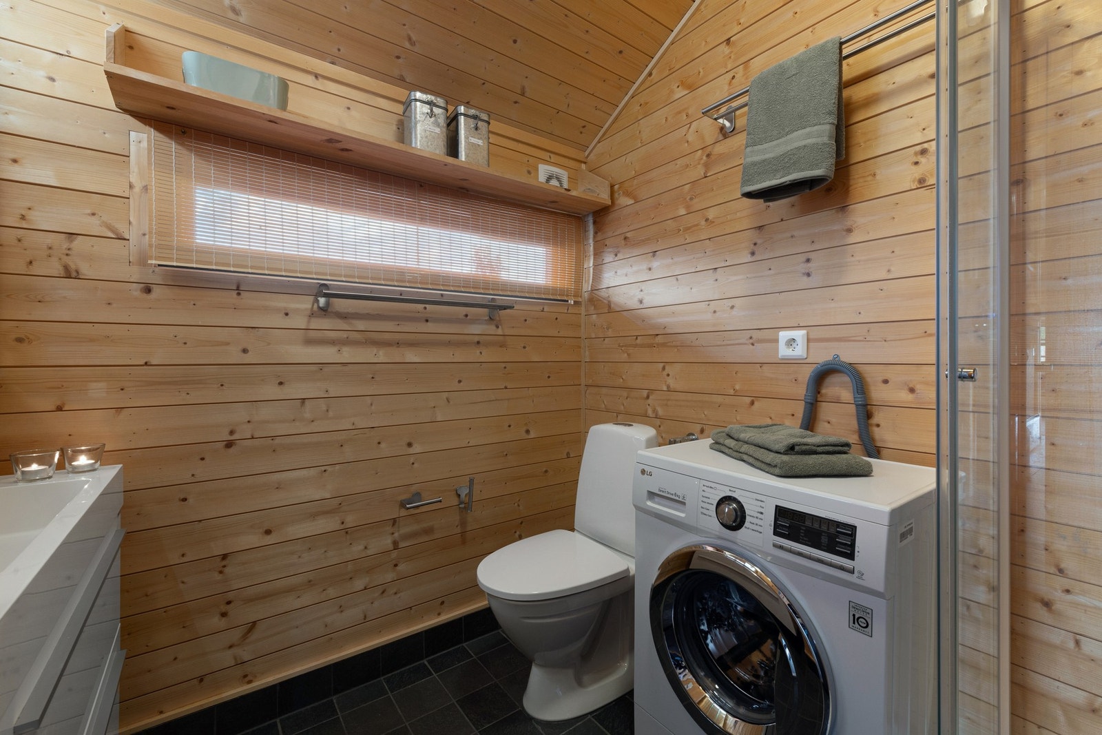 Badet er innredet med servant med innredning, dusj, toalett og opplegg for vaskemaskin. Galleribilde