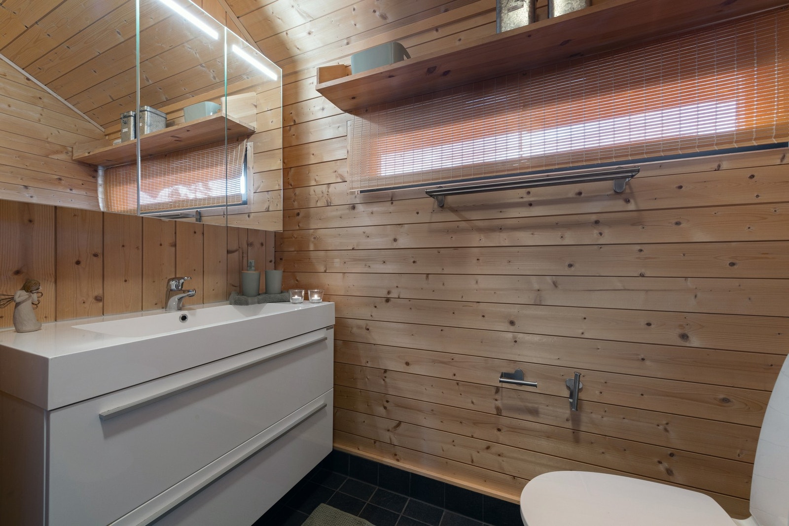 Badet har en fin løsning med plass til alt man trenger i et praktisk bad. Galleribilde