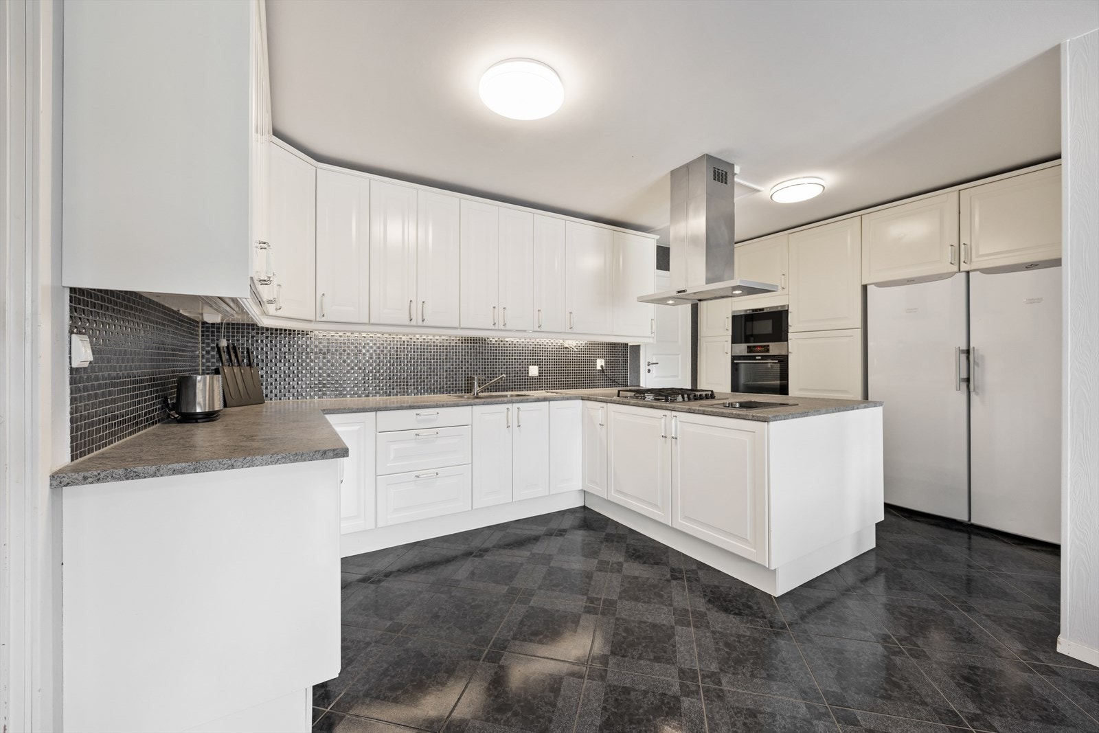 Stilrent og funksjonelt kjøkken med rikelig skap- og benkeplass. Galleribilde