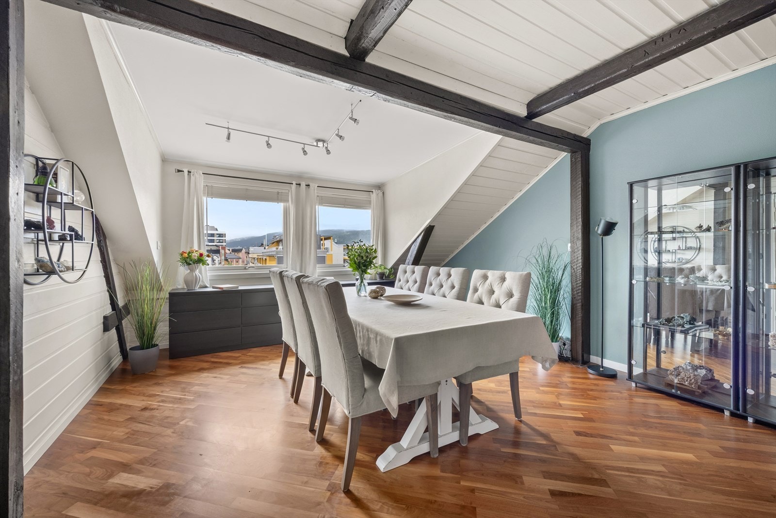 Spisestuen har store vinduer som har godt med lysinnslipp, og i kombinasjon med synlige takbjelker gir dette leiligheten det lille ekstra Galleribilde