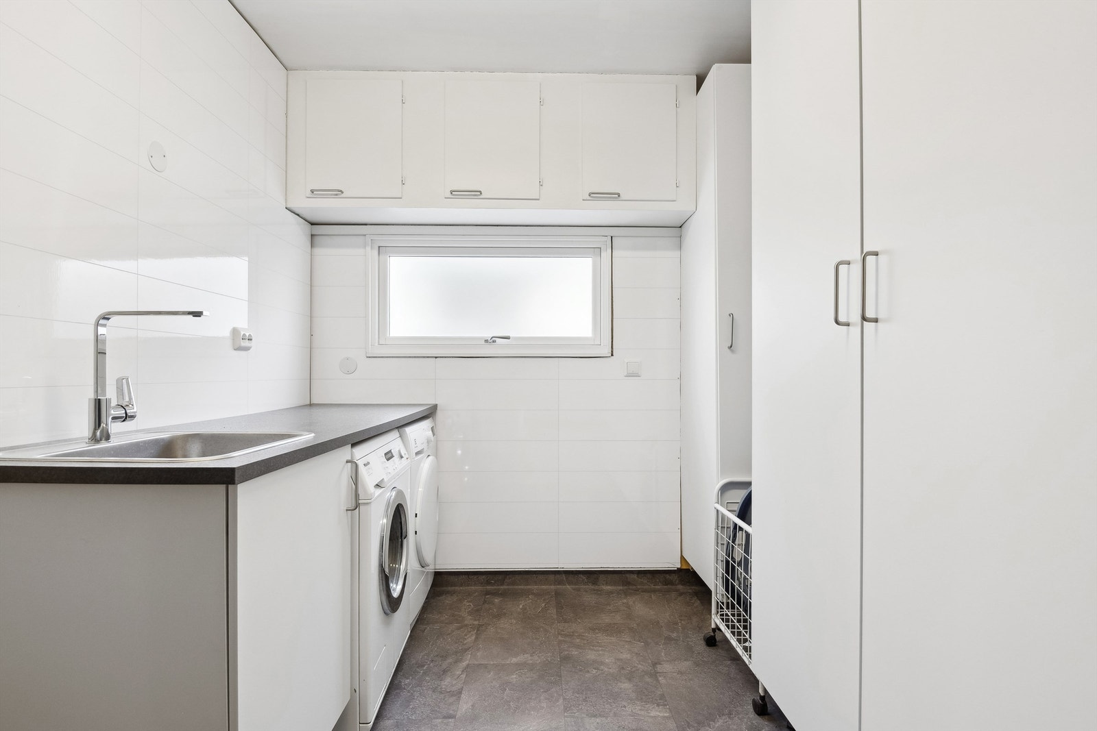 Vaskerom med innredning med plass til både vaskemaskin og tørketrommel. Rommet har ikke sluk og fremstår ikke som et komplett våtrom. Galleribilde