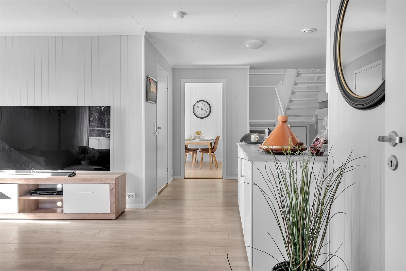 Den åpne løsningen mellom stue og kjøkken skaper en sosial og praktisk flyt, samtidig som en halvøy elegant definerer sonene. Galleribilde