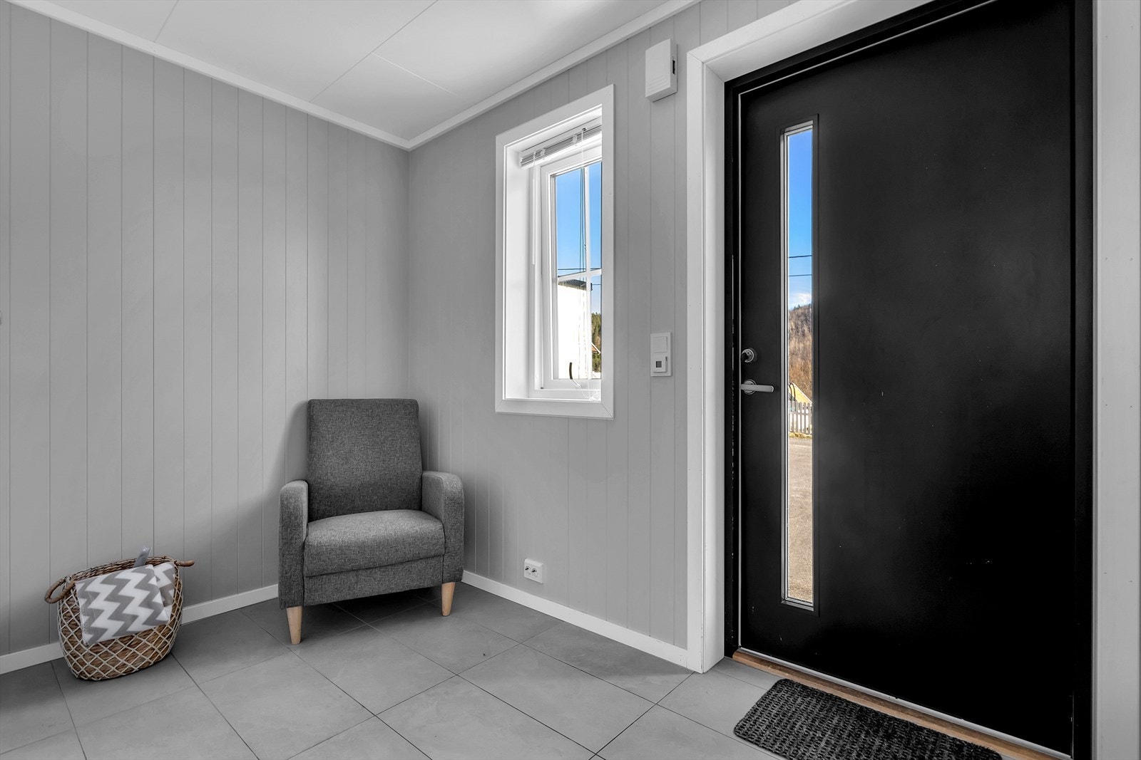 Entréen ønsker deg velkommen med et innbydende og stilrent preg som setter tonen for resten av boligen. Det flislagte gulvet er både praktisk og elegant med varmekabler som sørger for en lun og behagelig atmosfære, særlig på kalde dager. Galleribilde