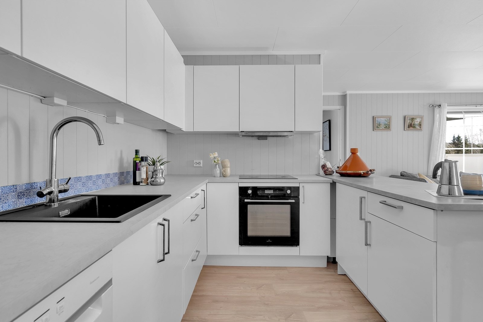 De integrerte hvitevarene, som platetopp og stekeovn, er diskret innfelt og skaper en sømløs og harmonisk helhet. Galleribilde