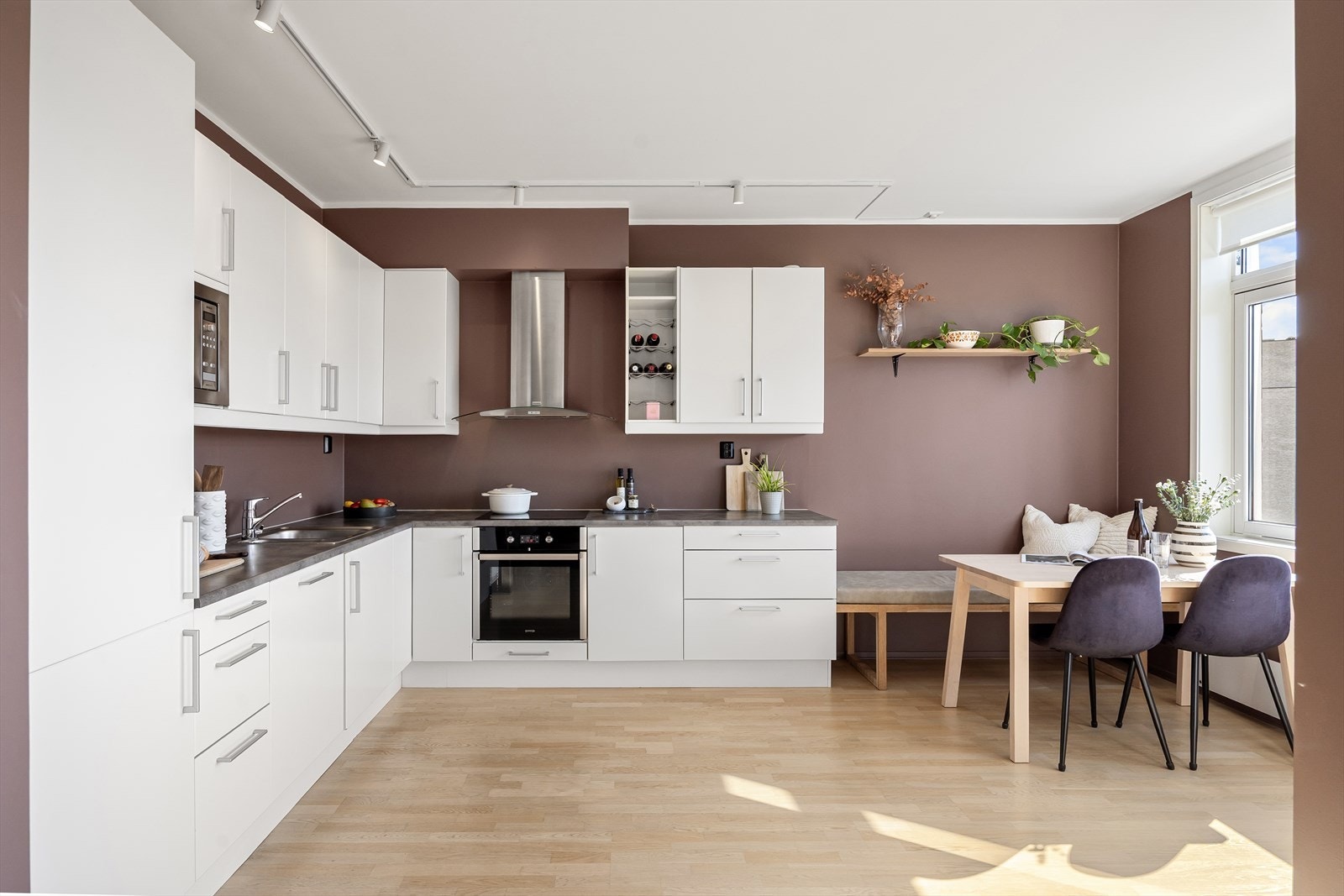 Innredningen har glatte fronter og en slitesterk laminatbenkeplate med nedfelt vaskekum, som gir et rent og elegant uttrykk. Under overskapene er det montert belysning som gir godt arbeidslys på benken. Galleribilde