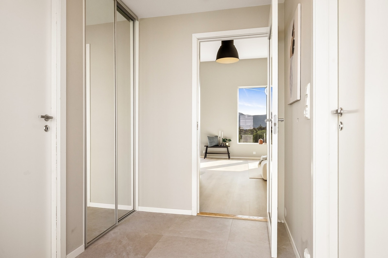Hall i 1 etasje med skyvedørsgarderobe og fliser på gulv. Galleribilde
