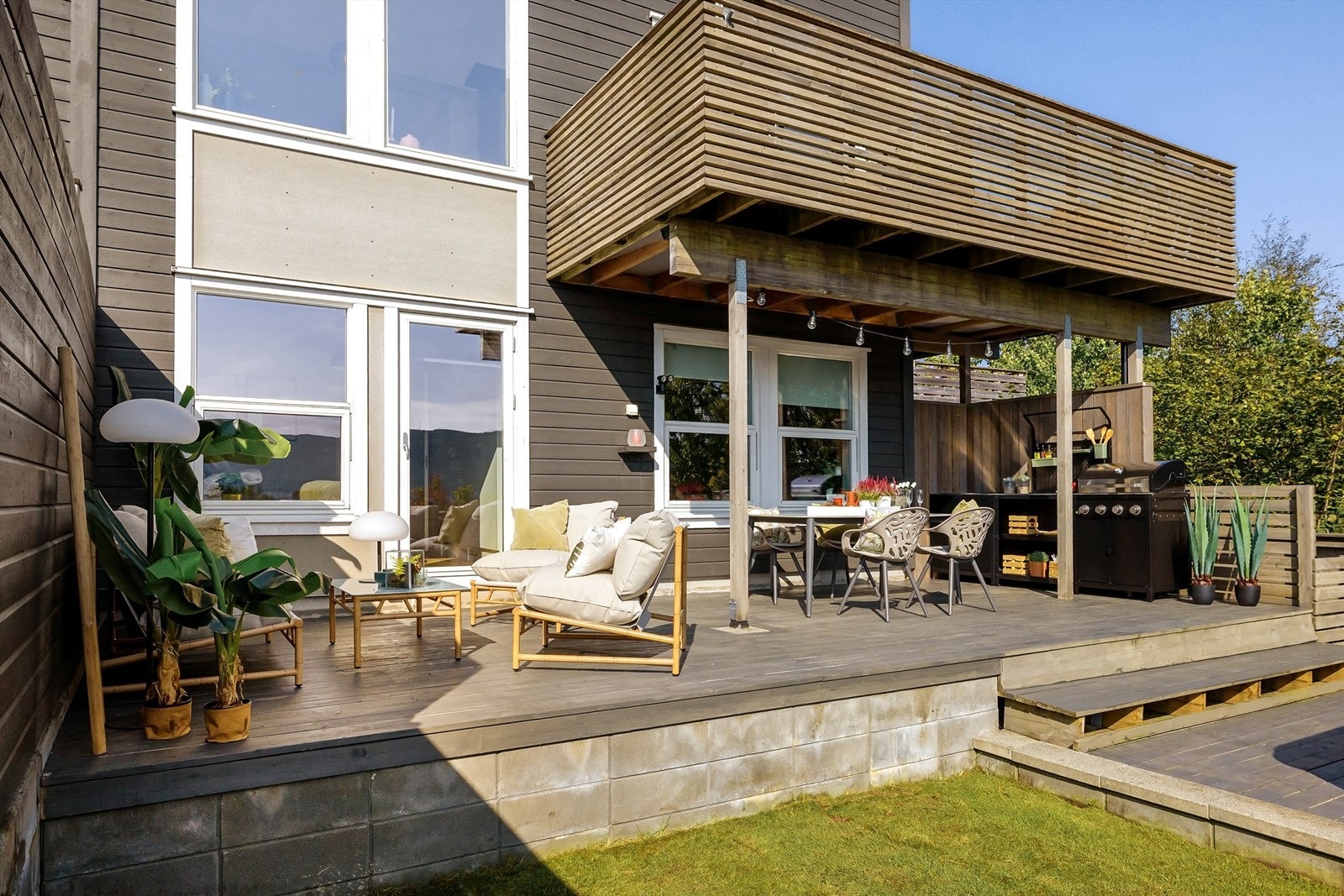 Nydelig uteområde med kombinasjon av plen og treterrasse. Galleribilde