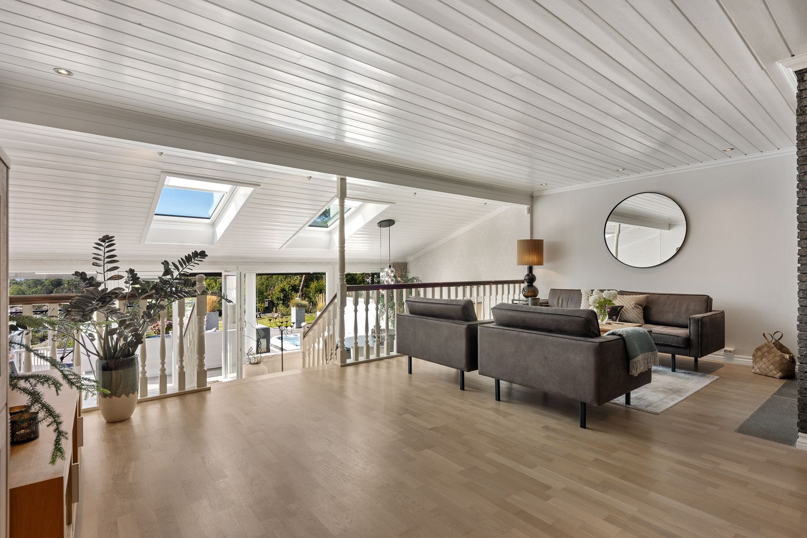 Lys og luftig stue med skråtak og åpent mot et lavere plan. Galleribilde