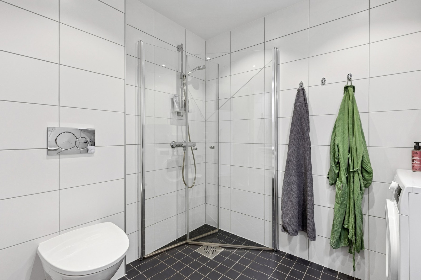 Badet har toalett, dusjhjørne med innfellbare glassdører og opplegg for vaskemaskin. Galleribilde