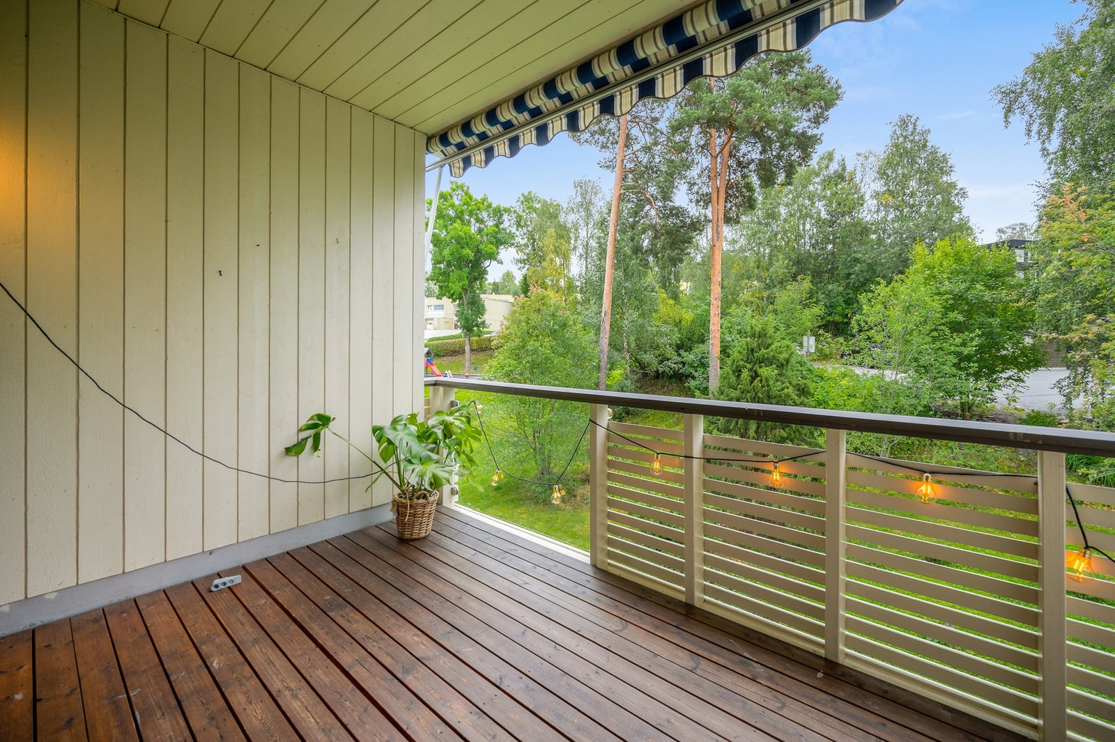 Balkong med markise og utsikt mot grøntområde. Galleribilde