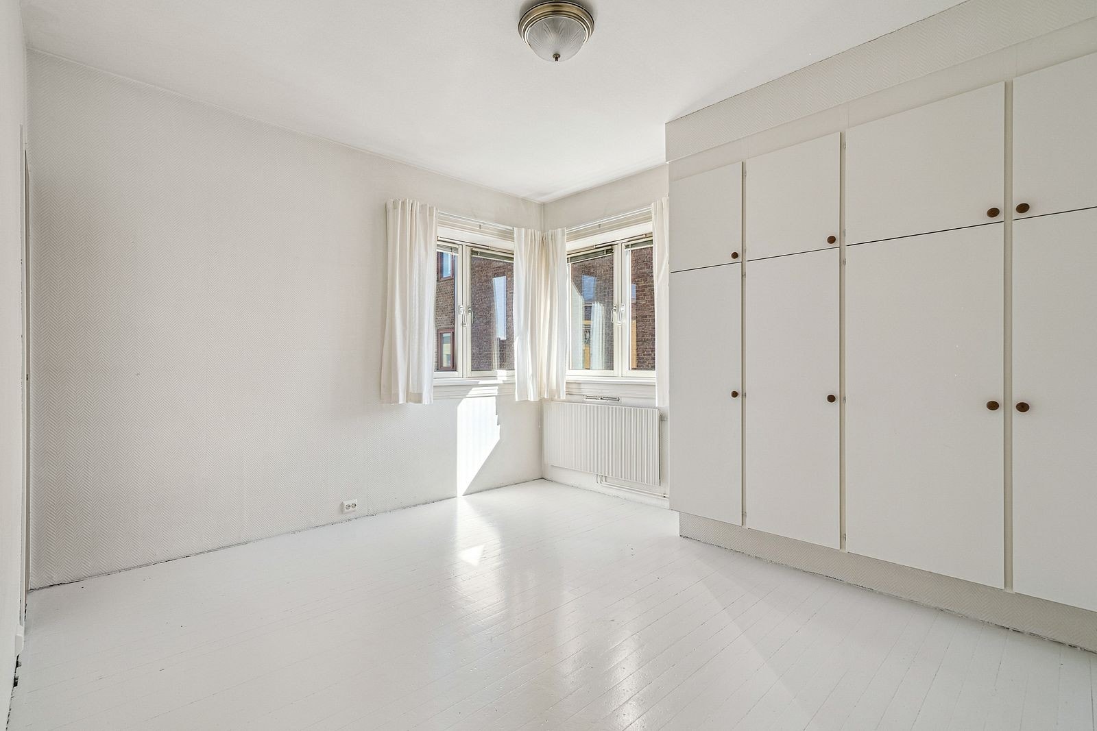 Luftig og lyst soverom med plassbygd med plassbygd garderobe Galleribilde