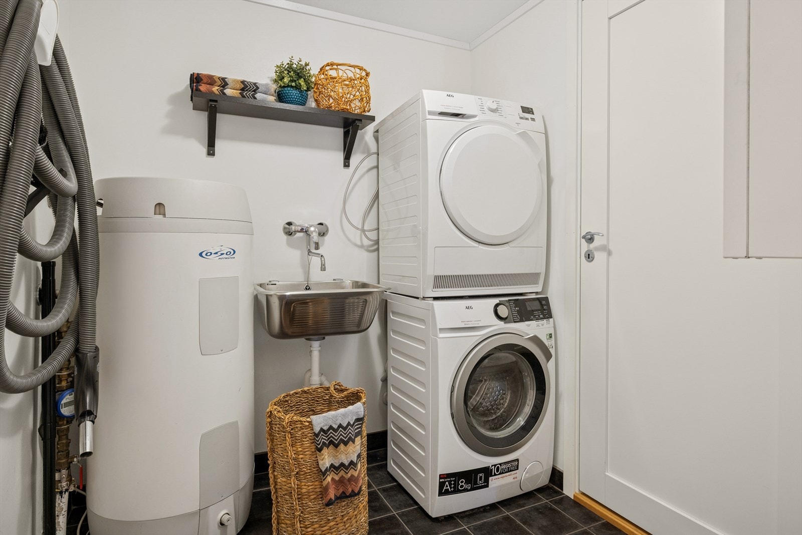 Praktisk vaskerom i 1. etasje. Flislagt gulv med varmekabler og malte plater på vegger. Direkte adkomst til bod. Galleribilde