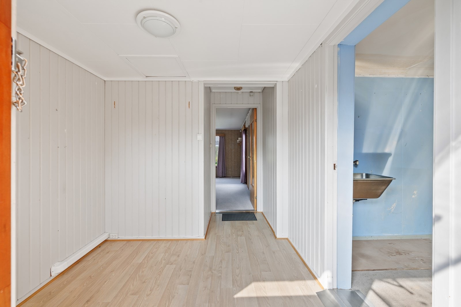 Her kommer du inn i en romslig entrè/vindfang. Det er plass til en garderobeløsning i gangen for yttertøy og skotøy Galleribilde