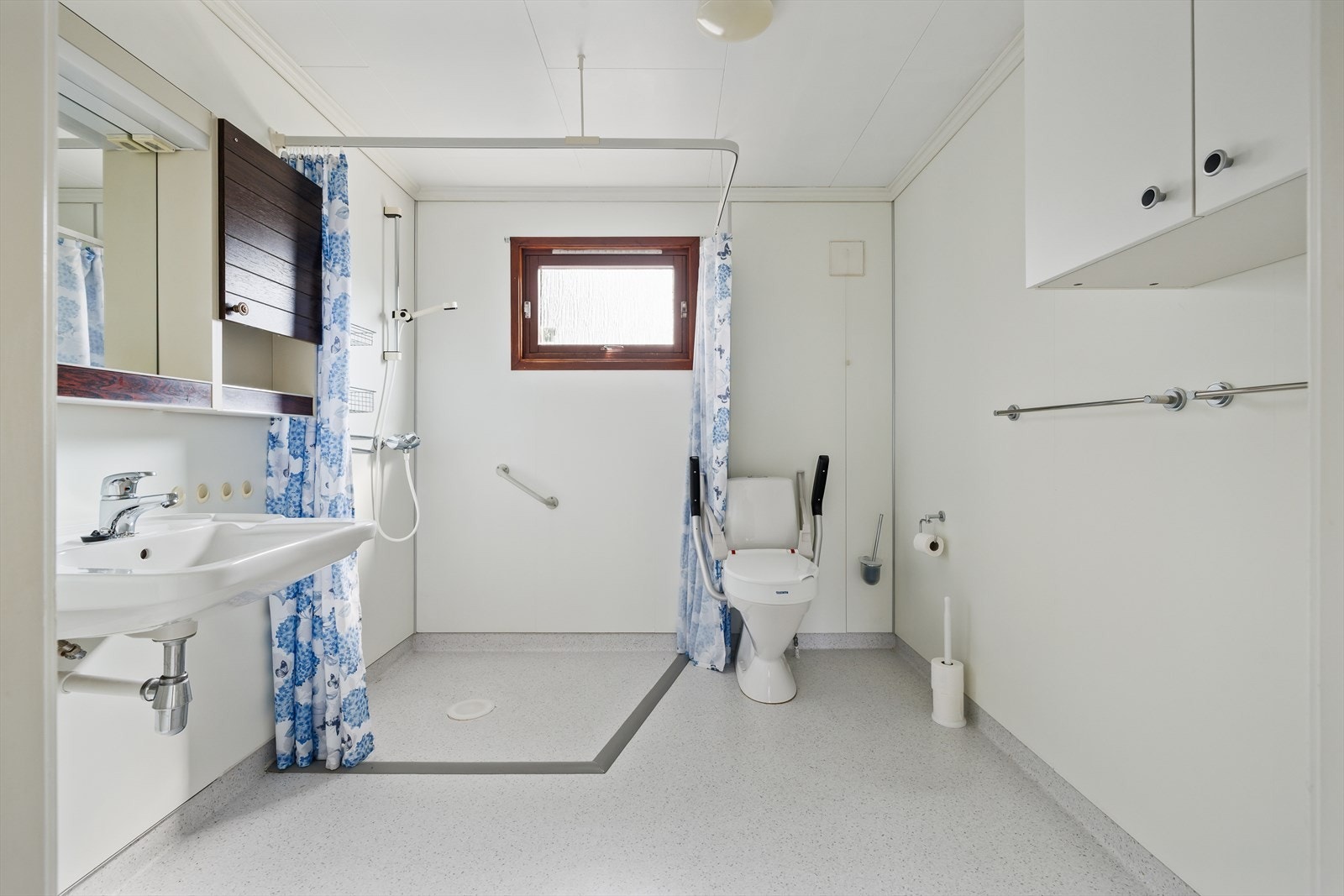 Badet har i dag universell utforming tilpasset rullestolbruker. Det er elektriske varmekabler på gulvet. Rommet er innredet med servant, toalett og dusjhjørne med forheng Galleribilde