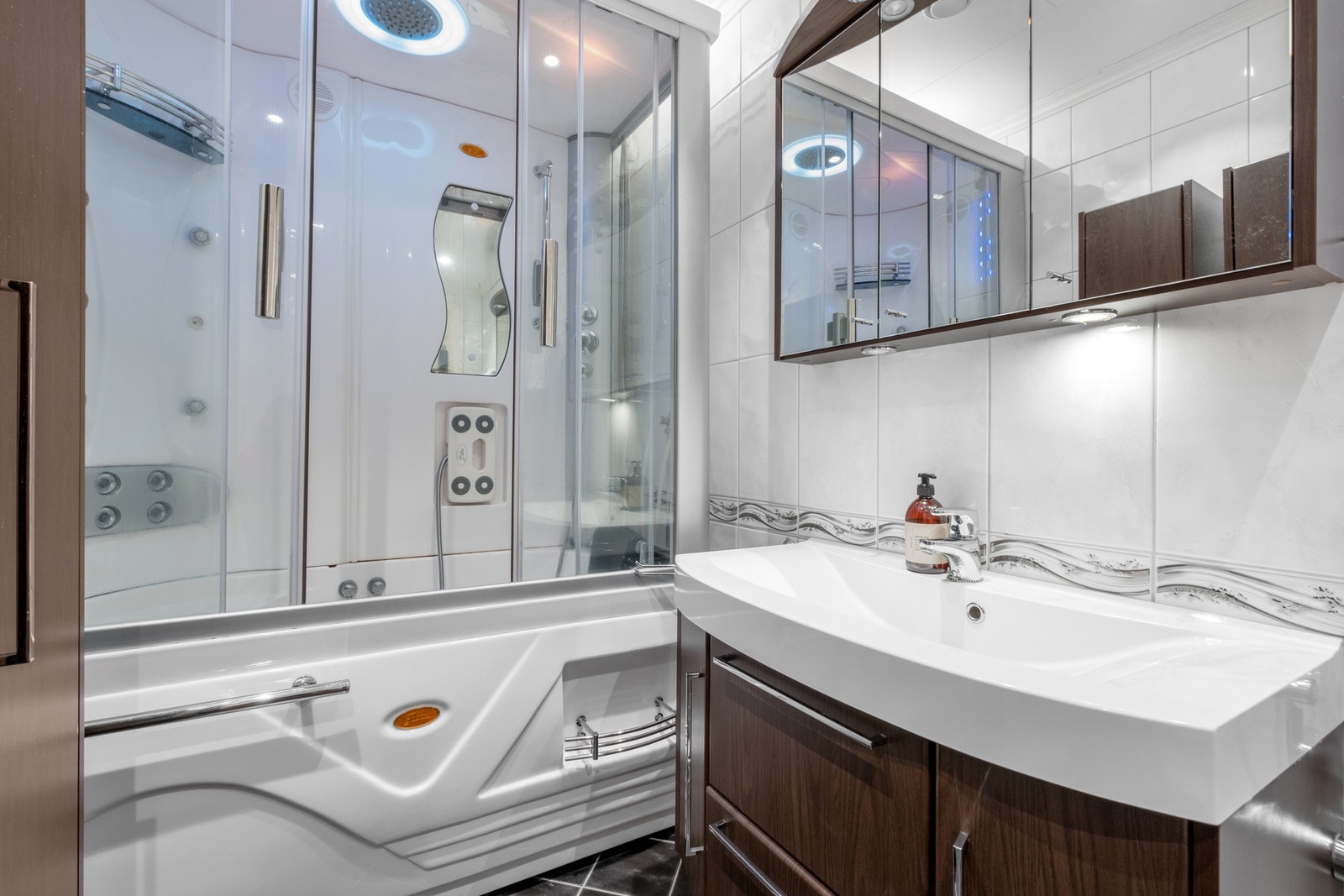 Utstyrt med boblekar, dusjhjørne, veggmontert wc, servant, servantskap og mekanisk avtrekk. Galleribilde