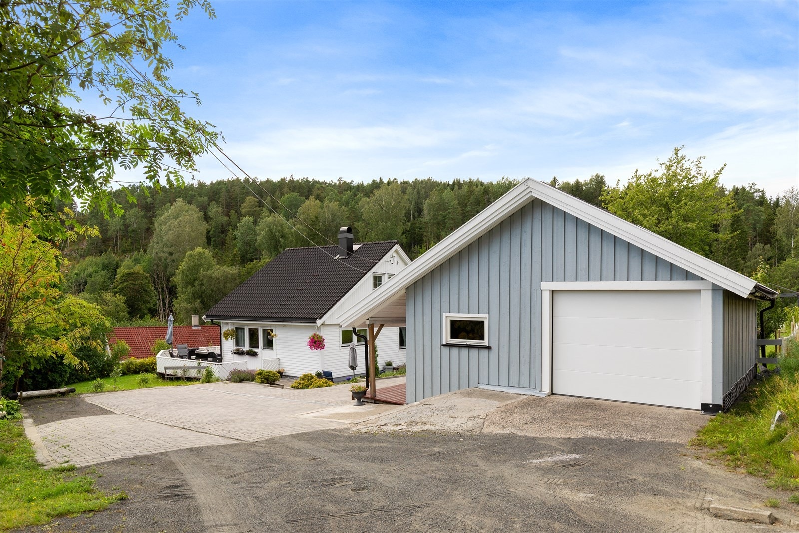 Frittstående garasje med automatisk port, elbillader, hems og sydvendt overbygd veranda. Delt i garasje og innredet rom (ikke godkjent for varig opphold). For mer informasjon, se pkt. om ferdigattest. Galleribilde