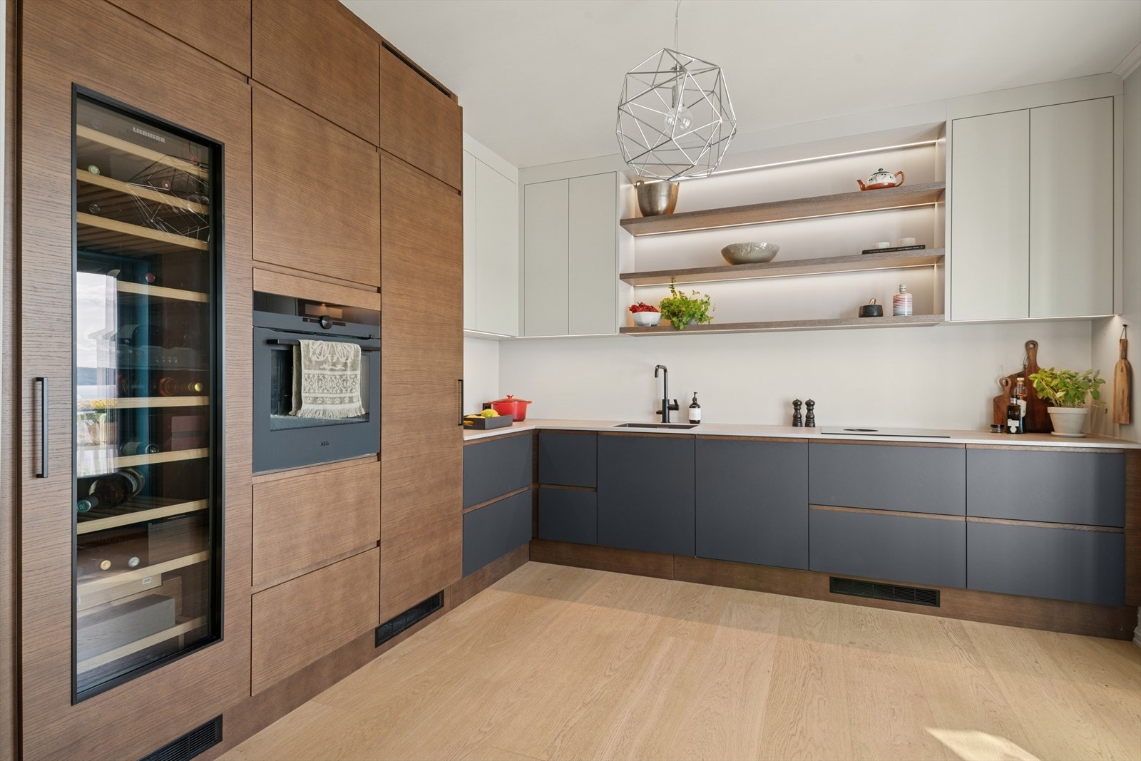 Kjøkken med påkostete hvitevarer som stort vinskap. Galleribilde