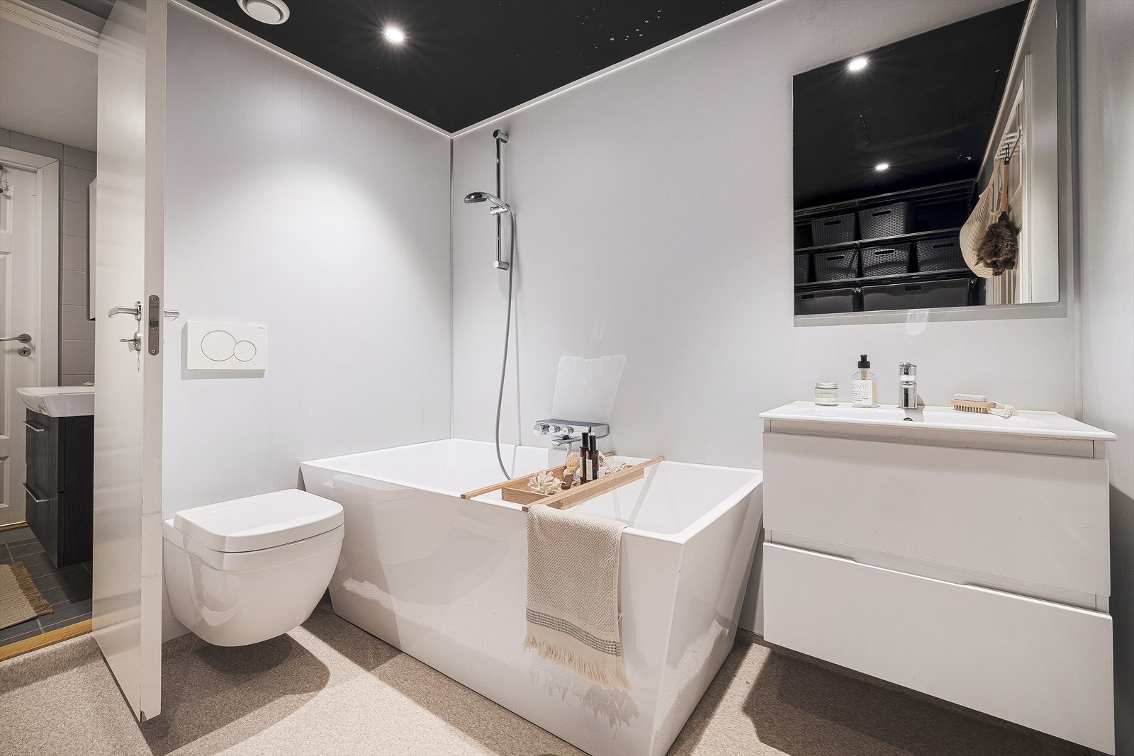 Fra det ene badet kommer du videre inn i et tilknyttet baderom med badekar, toalett, servant og en praktisk vaskeromsnisje. Galleribilde