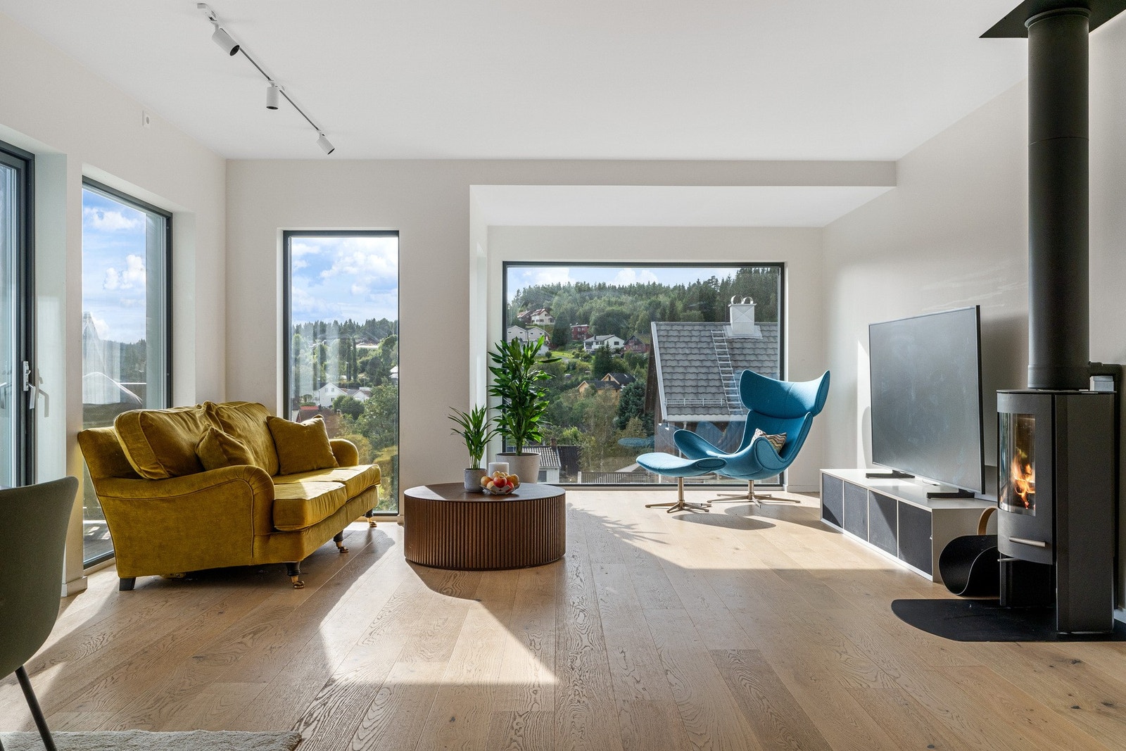 Store vindusflater med gjennomlys. Rentbrennende vedovn. Galleribilde