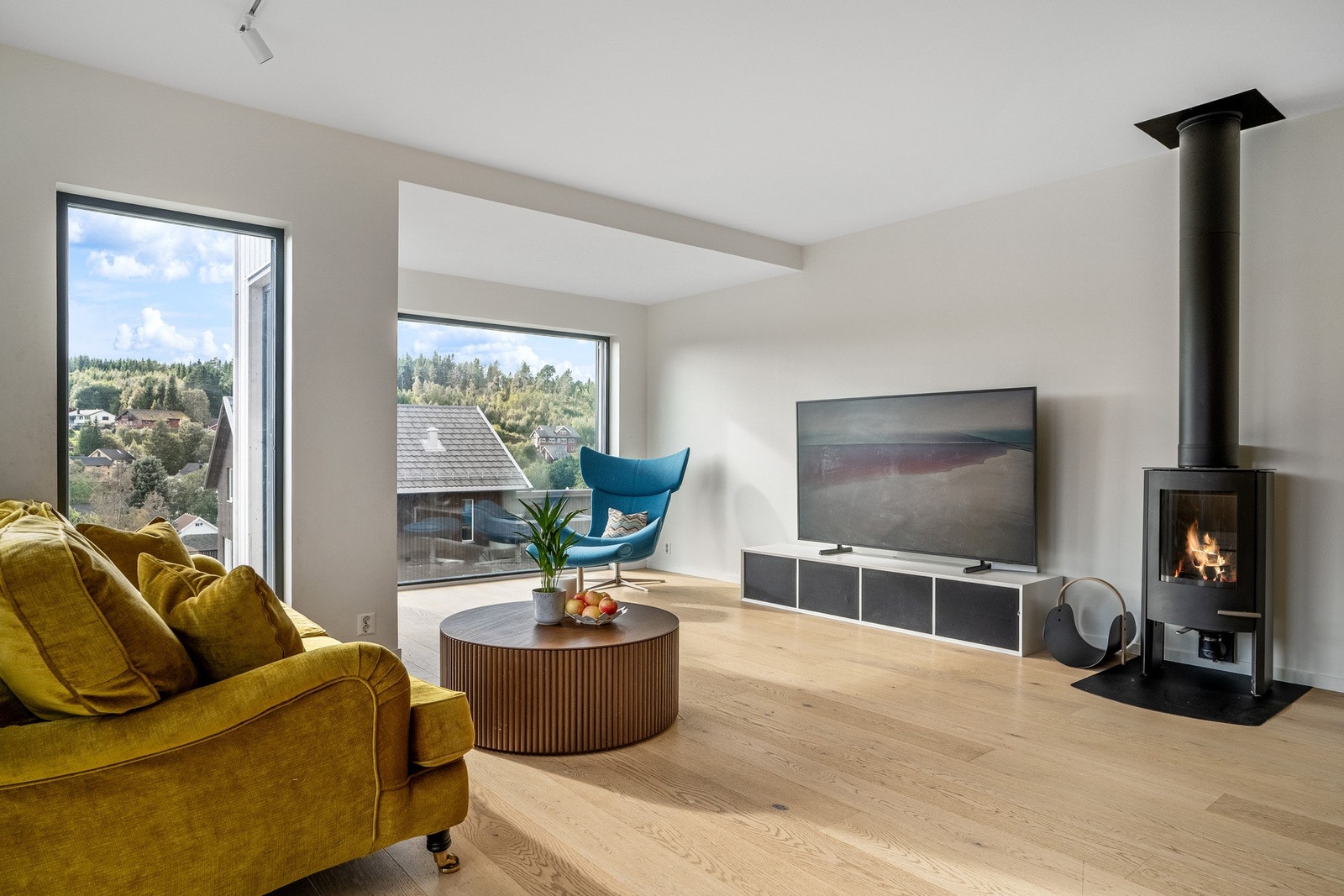 Kombinert stue-/ kjøkkenløsning på hele 54 kvm. Peisen er foreløpig ubrukt. Galleribilde