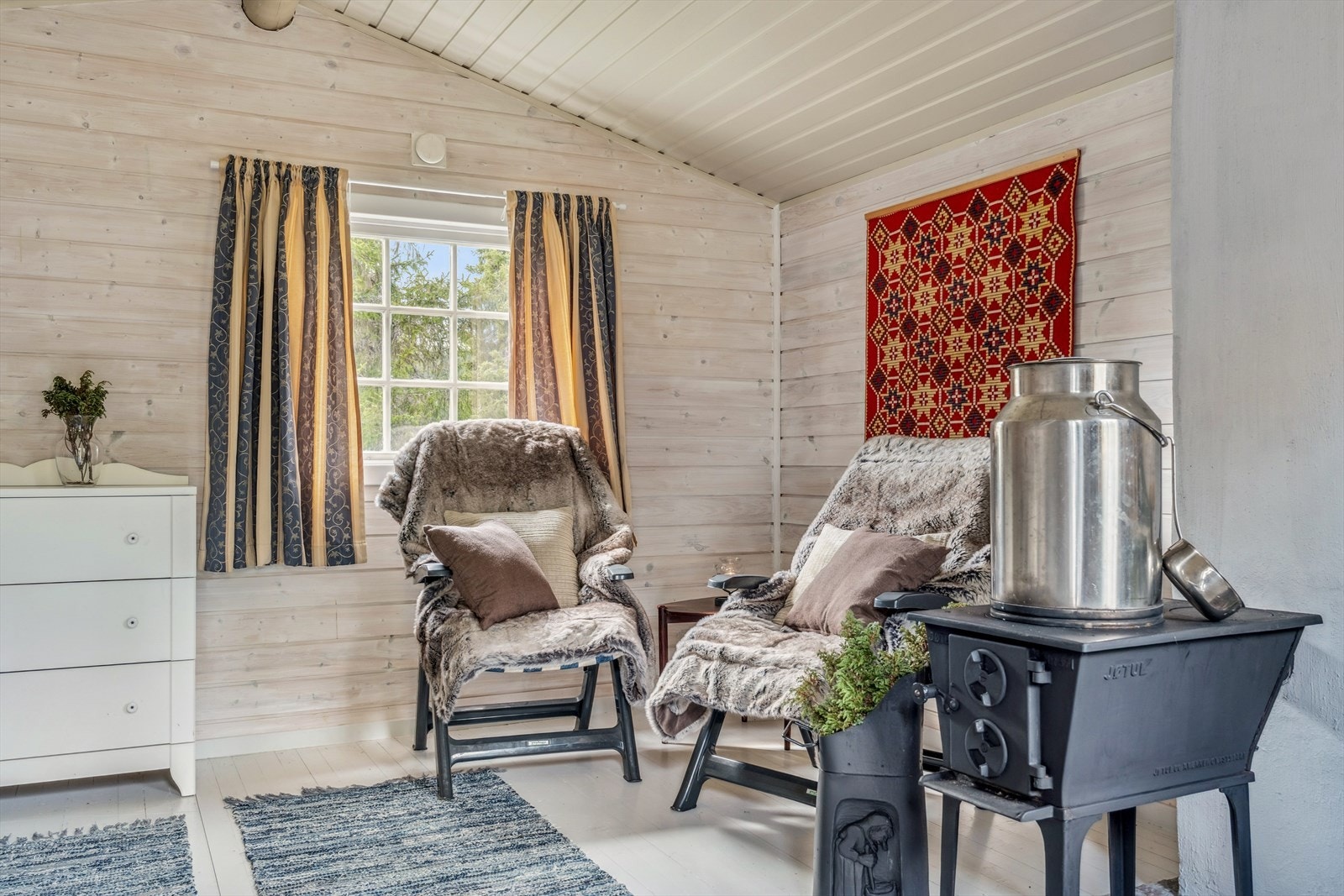 Det er innredet med soveplass, koselig sittegruppe og vedovn. Galleribilde