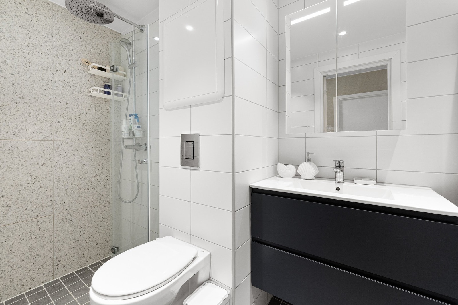 Varmekabler på gulv. Romslig dusjnisje med waterfall- og hånddusj. Det er opplegg for både vaskemaskin og tørketrommel på badet. Galleribilde