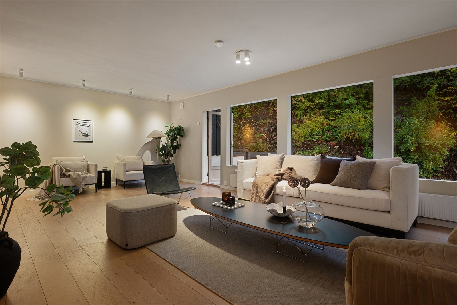 Romslig L-formet stue med flere gode møbleringssoner og ildsted Galleribilde