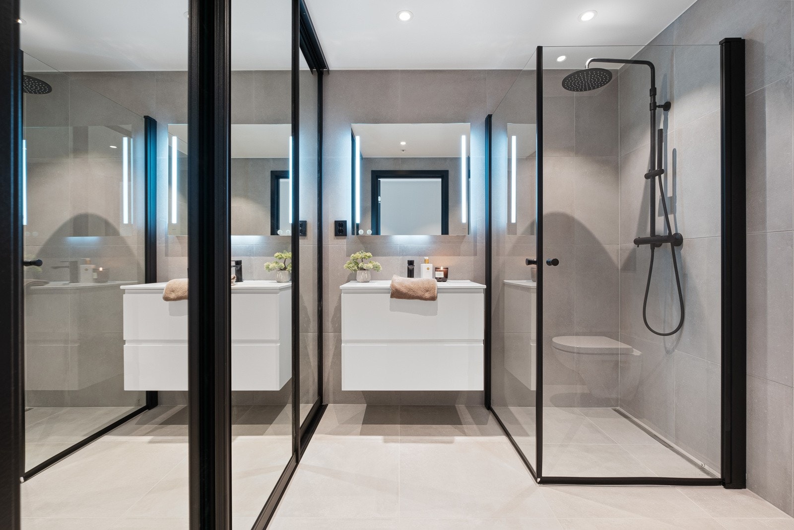 Det andre badet er både stort og praktisk. Her med dusj og integrerte armaturer. Skapet til venstre skjuler diskret både vaskemaskin og tørketrommel. Galleribilde