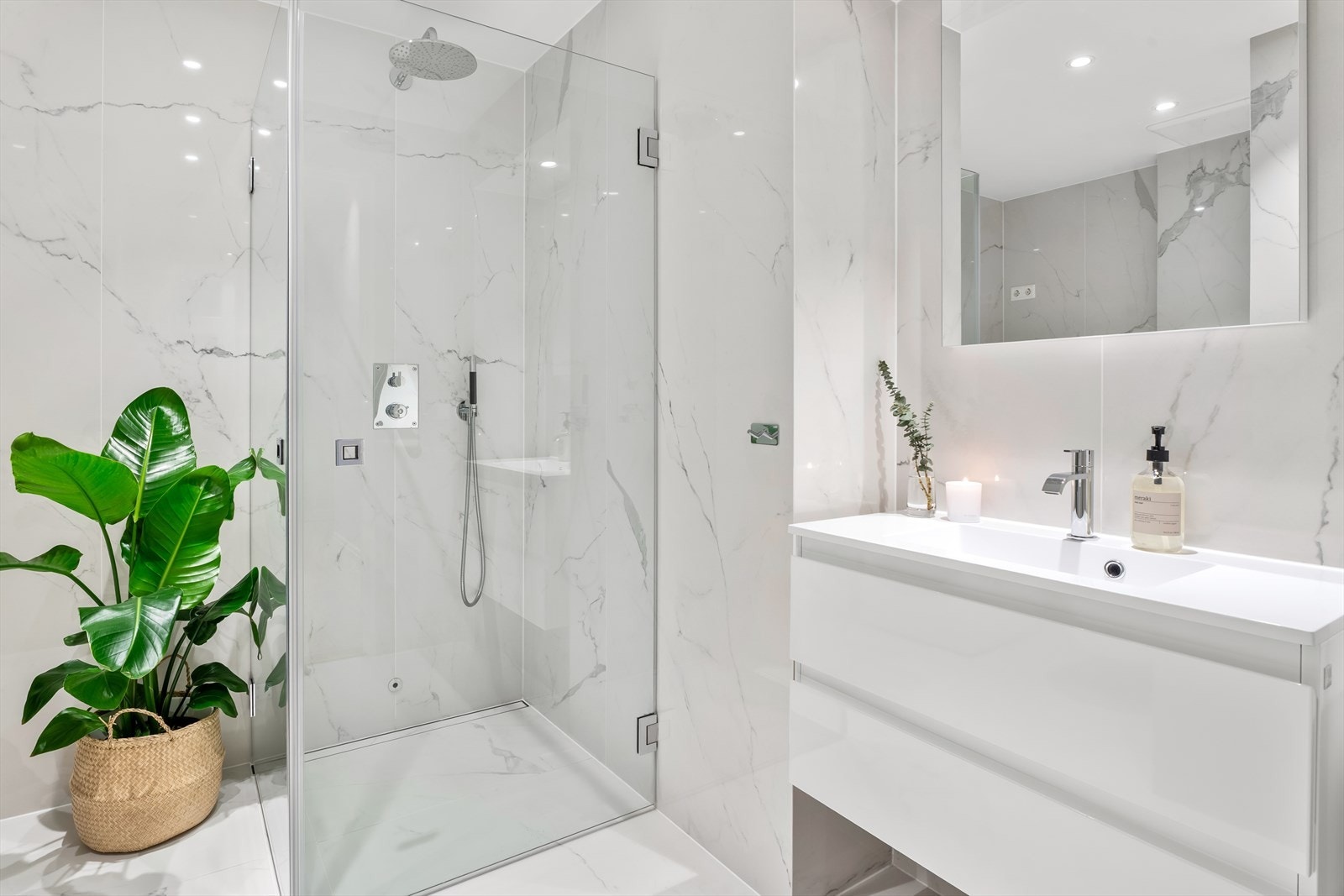 Dusjhjørne med glassdører, tile-insert linjesluk og innebygget takdusj og hånddusj fra Tapwell. Baderomsinnredning med store skuffer og armatur fra Tapwell samt vegghengt speil. Galleribilde