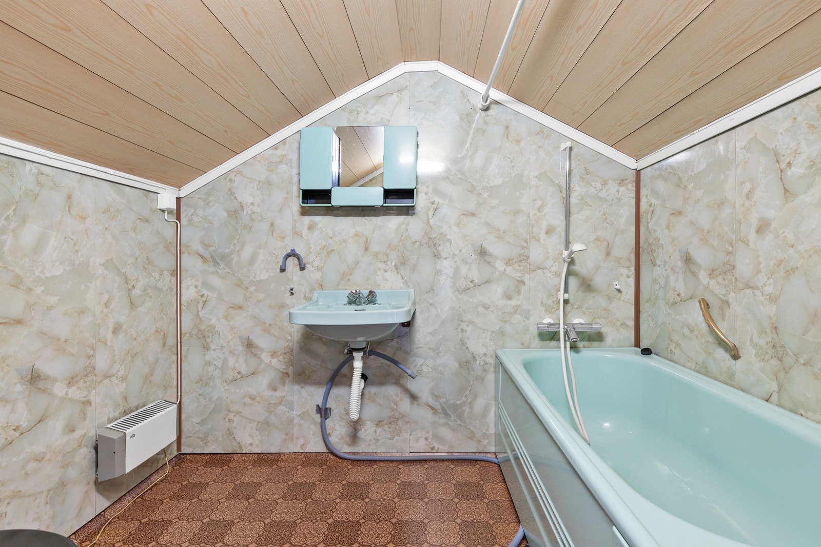 Bad med belegg på gulv, baderomsplater på vegger og panel i himling. Badet har sanitærutstyr som badekar, toalett og vask Galleribilde
