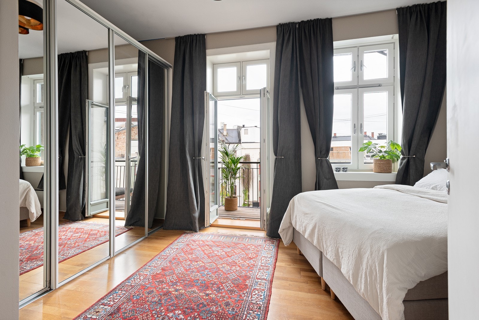 Stort soverom med plassbygget skyvedørsgarderobe som gjør oppbevaring av klær til en drøm Galleribilde