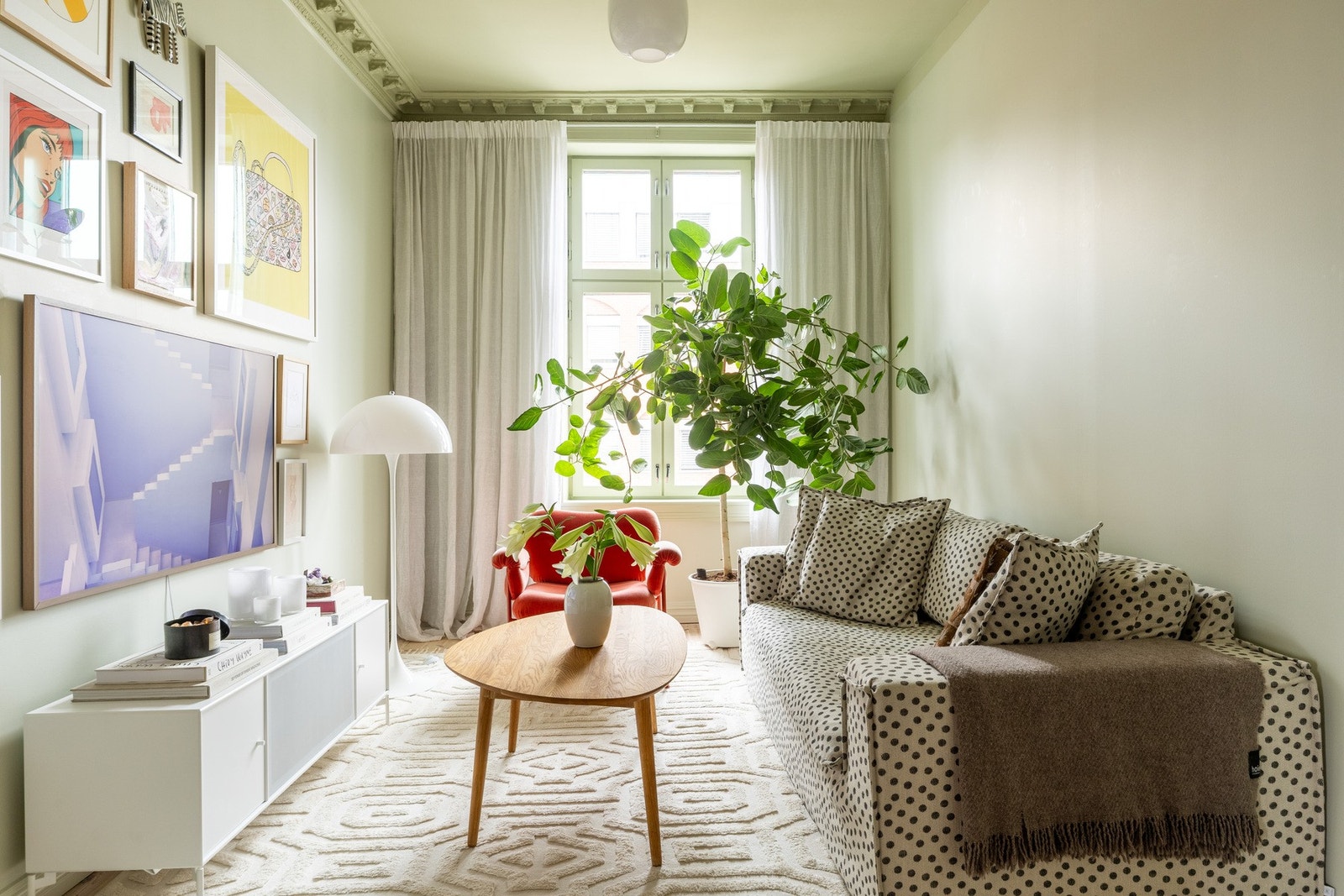 Luftig stue malt i en grønn-fargetone, som skaper et pent uttrykk sammen med resten av leilighetens fargevalg. Galleribilde