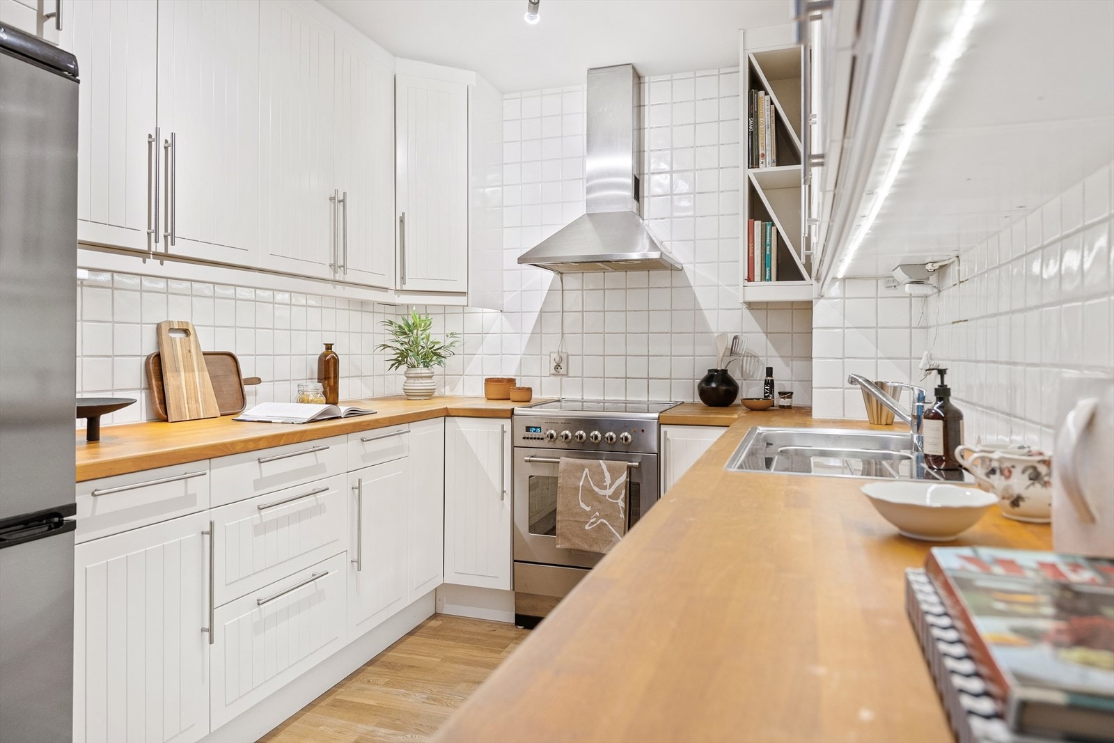 Kjøkkeninnredning med profilerte fronter og heltre benkeplate med nedfelt oppvaskkum Galleribilde