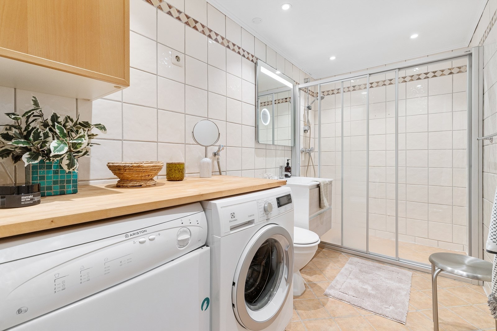 Stort, helfliset bad med varmekabler i gulv og downlights i himling. Benkeplate med plass til vaskemaskin og tørketrommel under Galleribilde