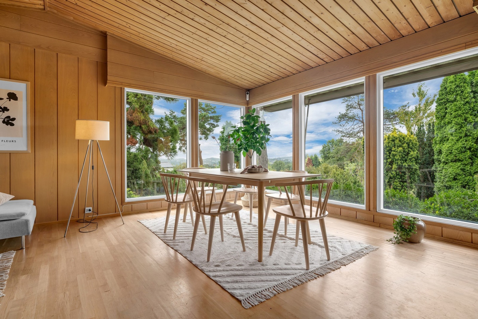 En spisestue som kombinerer lys, luft og grønne omgivelser Galleribilde